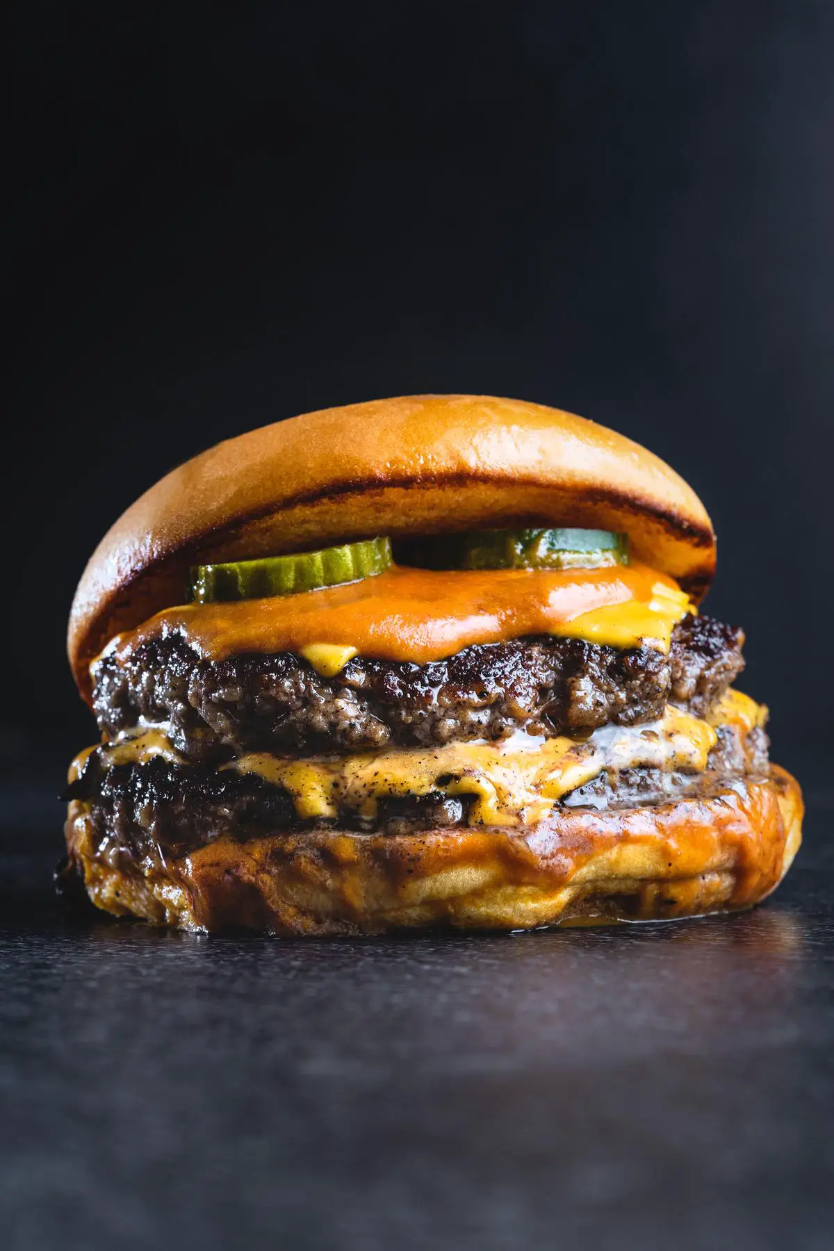A mouthwatering image of the McCrispy BBQ Smokehouse, filled with flame-grilled patty, cheese, bacon, onions, pickles, mayo, and lettuce. It represents a gourmet burger that showcases a perfect blend of flavors and textures.